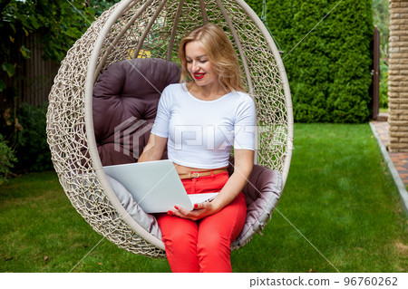 girl with a laptop in the garden 96760262