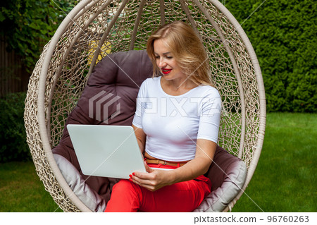 girl with a laptop in the garden 96760263
