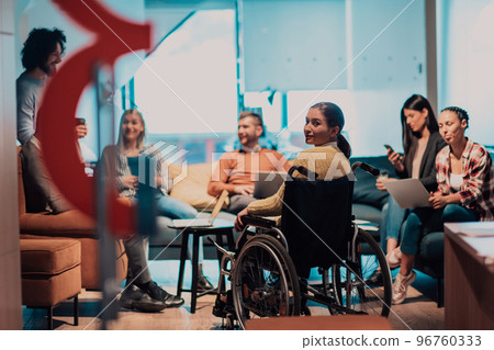 Businesswoman in wheelchair having business meeting with team at modern office. A group of young freelancers agree on new online business projects Businesswoman in wheelchair having business meeting with team at modern office. A group of young freelancers agree on new online business projects 96760333