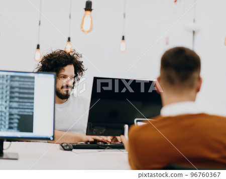 Group of multi-ethnic colleagues working on desktop computers, laptop and sharing their ideas in a modern office space.Young influencers work on online marketing projects. 96760367