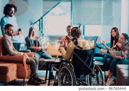 Businesswoman in wheelchair having business meeting with team at modern office. A group of young freelancers agree on new online business projects Businesswoman in wheelchair having business meeting with team at modern office. A group of young freelancers agree on new online business projects 96760444