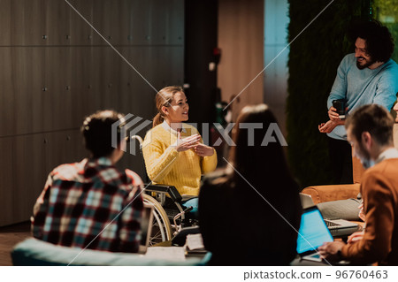 Businesswoman in wheelchair having business meeting with team at modern office. A group of young freelancers agree on new online business projects Businesswoman in wheelchair having business meeting with team at modern office. A group of young freelancers agree on new online business projects 96760463
