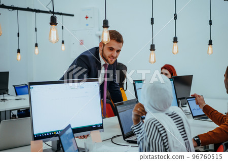 Multiethnic group of employees working in a marketing company. A group of colleagues is working on a project in modern offices Multiethnic group of employees working in a marketing company. A group of colleagues is working on a project in modern offices 96760515
