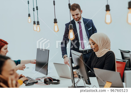 Multiethnic group of employees working in a marketing company. A group of colleagues is working on a project in modern offices Multiethnic group of employees working in a marketing company. A group of colleagues is working on a project in modern offices 96760523
