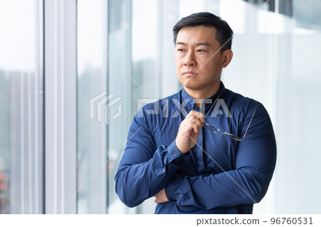 Thinking Asian businessman, man in shirt and glasses near office window, serious boss thinking about future plans and strategy. 96760531