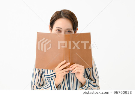 A woman who hides her face with a book 96760938