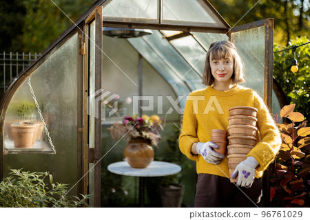 Woman with jugs in garden 96761029