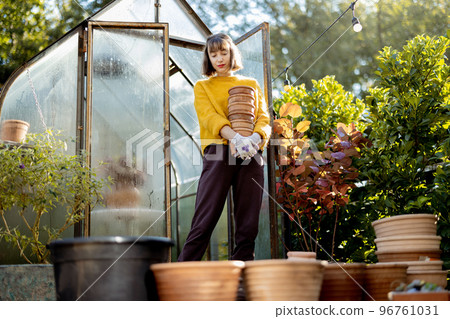 Woman with jugs in garden 96761031