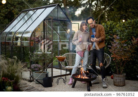 Young couple by the fire at backyard Young couple by the fire at backyard 96761052