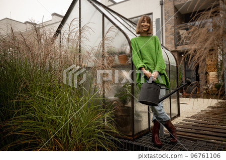 Woman near greenhouse at backyard 96761106