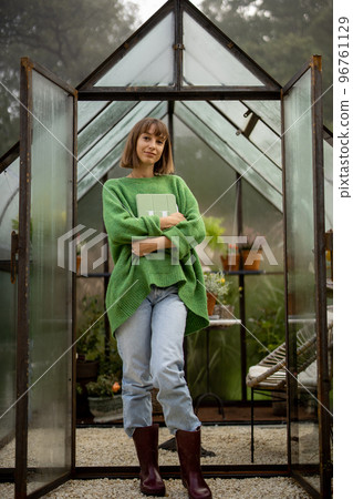 Woman near greenhouse in garden 96761129
