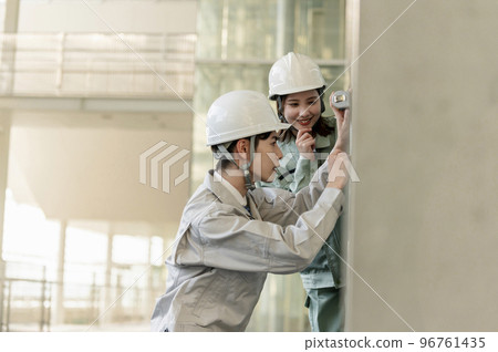 一名男初級工程師在一名女高級工程師的指導下工作 96761435