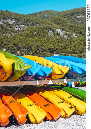 Colored kayak canoes on the sea beach. Summer holidays and activities on the water. Vacation, relax, sport concept. 96763373