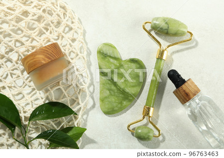 Face care concept with gua sha, face roller and cosmetic Face care concept with gua sha, face roller and cosmetic 96763463