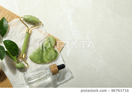 Face care concept with gua sha, face roller and cosmetic Face care concept with gua sha, face roller and cosmetic 96763716