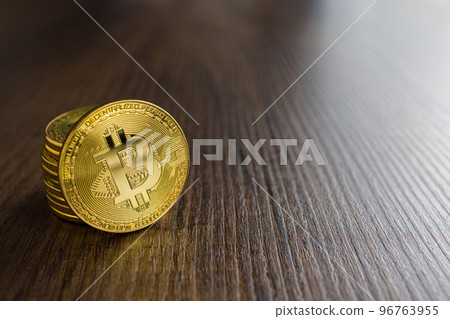 Cryptocurrency. Bitcoin virtual money. Golden coin on wooden table. Cryptocurrency. Bitcoin virtual money. Golden coin on wooden table. 96763955