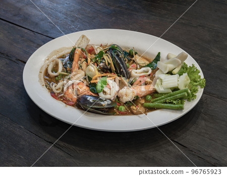 Stir-Fried Spicy seafood with herbs and spices served on white plate. Authentic thai food. 96765923