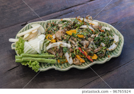 Spicy stir-fried wild boar with herbs and black peppers on green ceramic. Authentic thai food. Spicy stir-fried wild boar with herbs and black peppers on green ceramic. Authentic thai food. 96765924