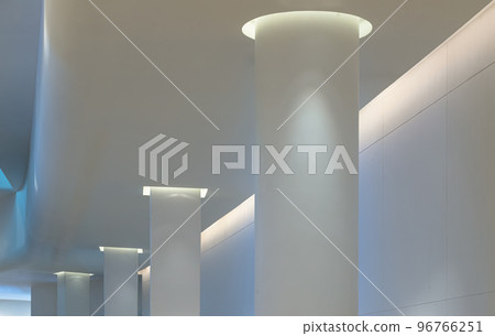 Concrete interior space with white round pillars arranged long lines lighting cast the shadow on the wall and pillars. Concrete interior space with white round pillars arranged long lines lighting cast the shadow on the wall and pillars. 96766251