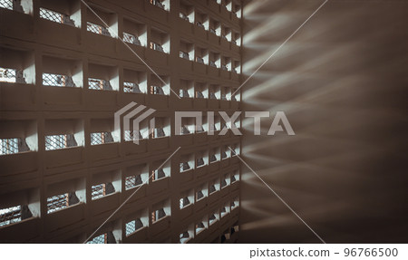 The sunlight shines through light channels wall of old gymnasium. Concrete walls have holes for sunlight to penetrate through the holes from the outside. The sunlight shines through light channels wall of old gymnasium. Concrete walls have holes for sunlight to penetrate through the holes from the outside. 96766500