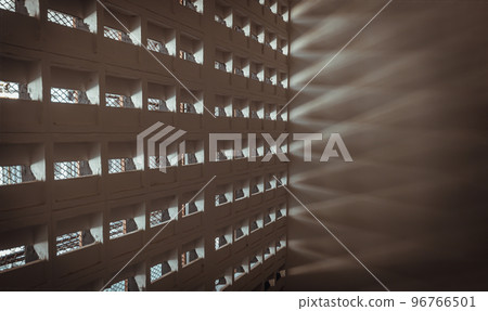 The sunlight shines through light channels wall of old gymnasium. Concrete walls have holes for sunlight to penetrate through the holes from the outside. The sunlight shines through light channels wall of old gymnasium. Concrete walls have holes for sunlight to penetrate through the holes from the outside. 96766501