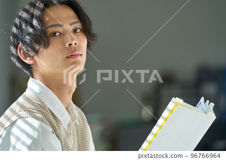 Young man reading by the window Young man reading by the window 96766964