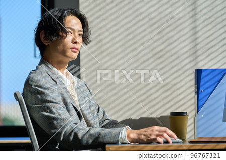 Young businessman working by the window in the office 96767321