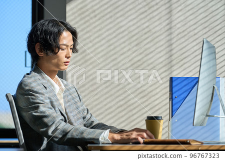 Young businessman working by the window in the office Young businessman working by the window in the office 96767323
