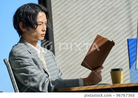 Young businessman working by the window in the office Young businessman working by the window in the office 96767368