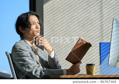 Young businessman working by the window in the office Young businessman working by the window in the office 96767369