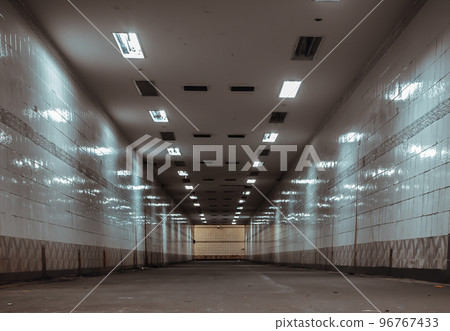Perspective view of Ambient public underpass with white tiled walls and stripes of ceiling neon lights. Perspective view of Ambient public underpass with white tiled walls and stripes of ceiling neon lights. 96767433