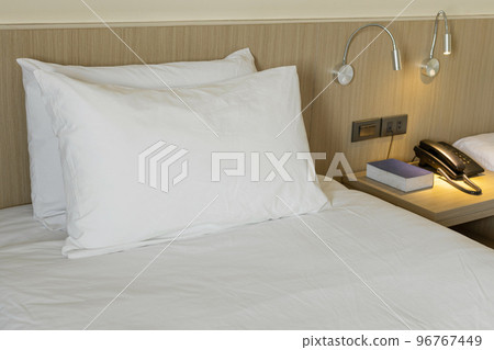 Modern bedroom interior with white pillow and bedside tables Modern bedroom interior with white pillow and bedside tables 96767449