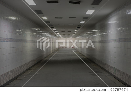 Perspective view of Ambient public underpass with white tiled walls and stripes of ceiling neon lights. Perspective view of Ambient public underpass with white tiled walls and stripes of ceiling neon lights. 96767474