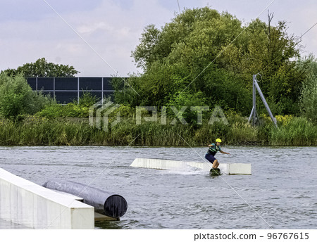 Teenager wakeboarding on a lake 96767615