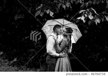 Young couple in love standing in the rain under an umbrella 96768738