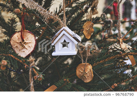Decorating Christmas tree with dried piece apple, toy house. Natural Xmas ornaments for Christmas tree, zero waste, soft focus Decorating Christmas tree with dried piece apple, toy house. Natural Xmas ornaments for Christmas tree, zero waste, soft focus 96768790