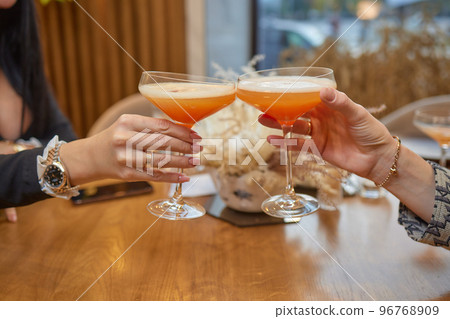 Clinking glasses with alcohol and toasting, party. 96768909