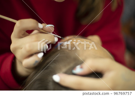 Face pattern. Applying paint to skin. Thin brush. Girl draws on skin. 96769757
