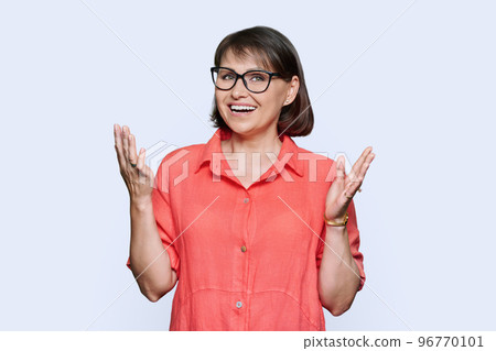 Portrait of mid adult woman in red dress looking at camera on white background 96770101
