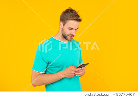 guy with bristle chatting on smartphone on yellow background, technology guy with bristle chatting on smartphone on yellow background, technology 96770407