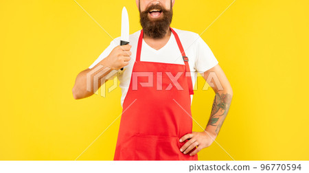 Happy man crop view holding cooks knife wearing red apron yellow background, cook 96770594