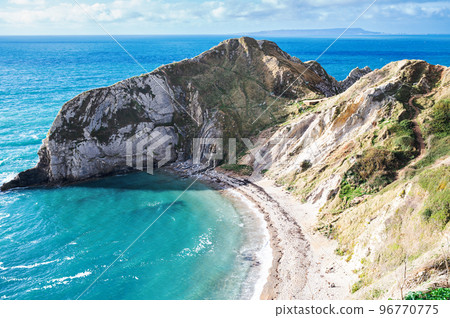 Beautiful views of nature on way to Durdle door in Lulworth, Dorset, United Kingdom. Part of Jurassic Coast World Heritage Site, view of stone rock formations and blue turquoise sea, selective focus Beautiful views of nature on way to Durdle door in Lulworth, Dorset, United Kingdom. Part of Jurassic Coast World Heritage Site, view of stone rock formations and blue turquoise sea, selective focus 96770775