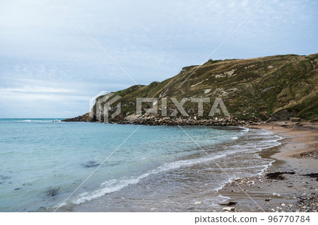 Lulworth Cove beach on cloudy weather in Dorset, United Kingdom. Part of Jurassic Coast World Heritage Site, view of stone cliffs and blue sea, selective focus Lulworth Cove beach on cloudy weather in Dorset, United Kingdom. Part of Jurassic Coast World Heritage Site, view of stone cliffs and blue sea, selective focus 96770784