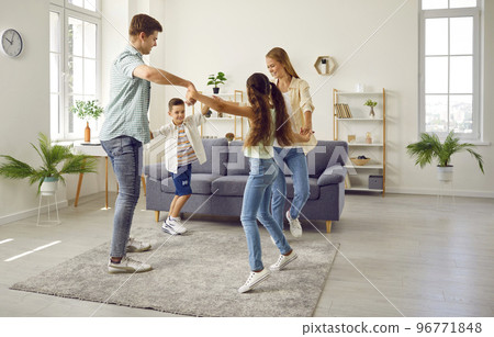 Happy family mom, dad, daughter and son playing leading a round dance at home in living room. 96771848
