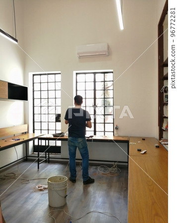 carpenter installing desks, shelves and wall storage modules. carpenter installing desks, shelves and wall storage modules. 96772281