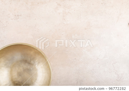 Tibetan singing bowl used during mantra meditations on beige stone background, top view, flat lay, copy space 96772282