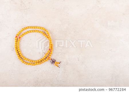 Japa wooden mala beads strands used for keeping count during mantra meditations on beige stone background 96772284