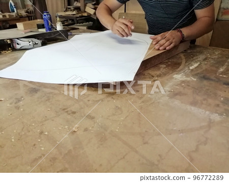 An Anonymous Carpenter Working on New Project at his Workshop. Table top view of unrecognizable man drawing n 96772289