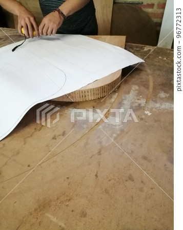 An Anonymous Carpenter Working on New Project at his Workshop. Table top view of unrecognizable man drawing n 96772313