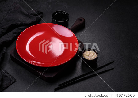 Empty plate with wooden sticks for Asian food on a dark concrete background 96772509